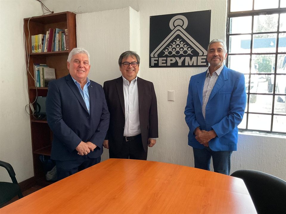 Manfredo Reyes Solares, Vicente Carrera y Carlos Roberto Samayoa de pie bajo el logo de FEPYME